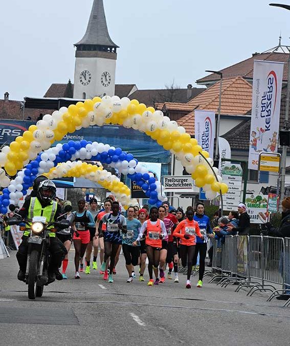 Coureurs sous un arc de ballons.